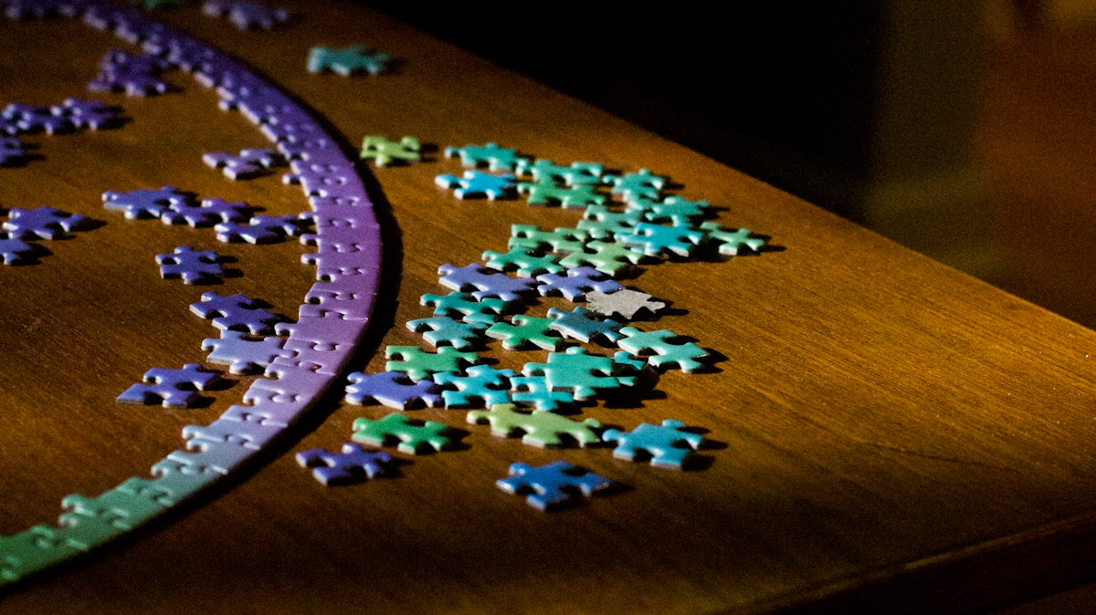 white and blue puzzle piece on brown wooden table