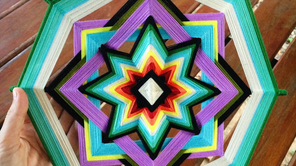 a person holding a colorful umbrella on top of a wooden table