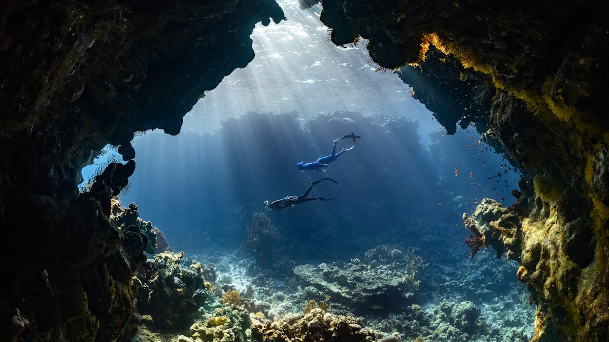 a scuba diver swims through an underwater cave