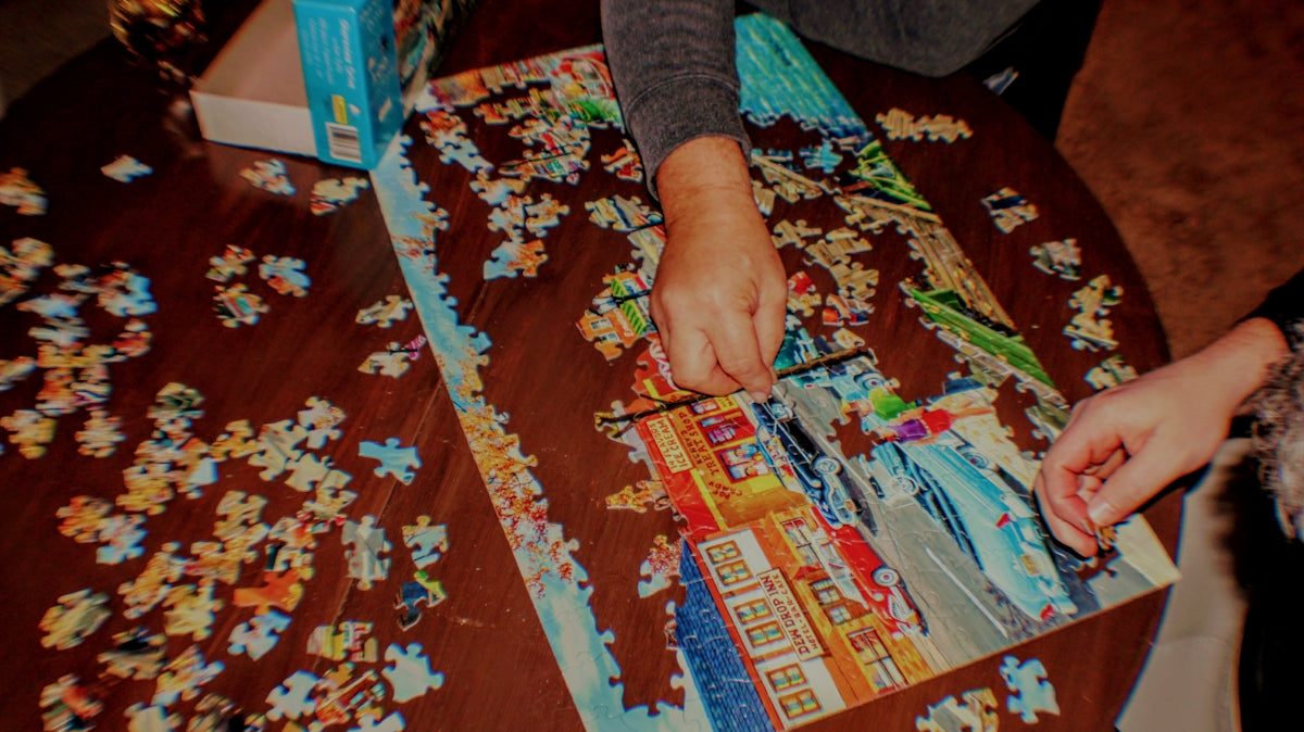 a person putting together a puzzle on a table