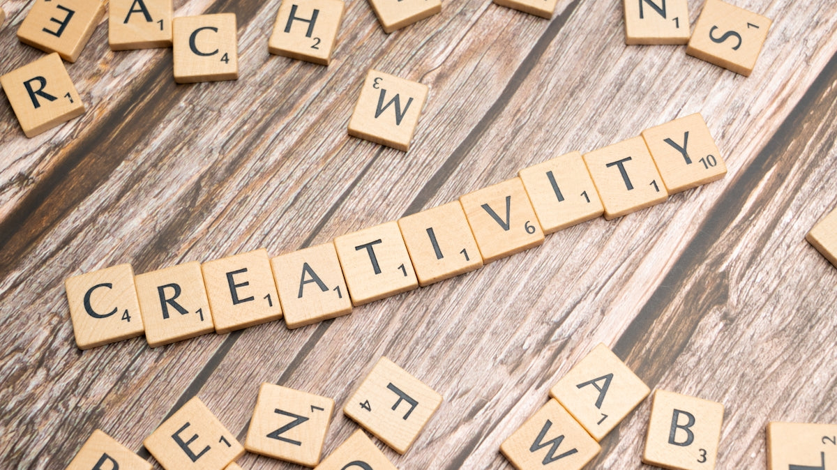 scrabble tiles spelling creativity on a wooden surface