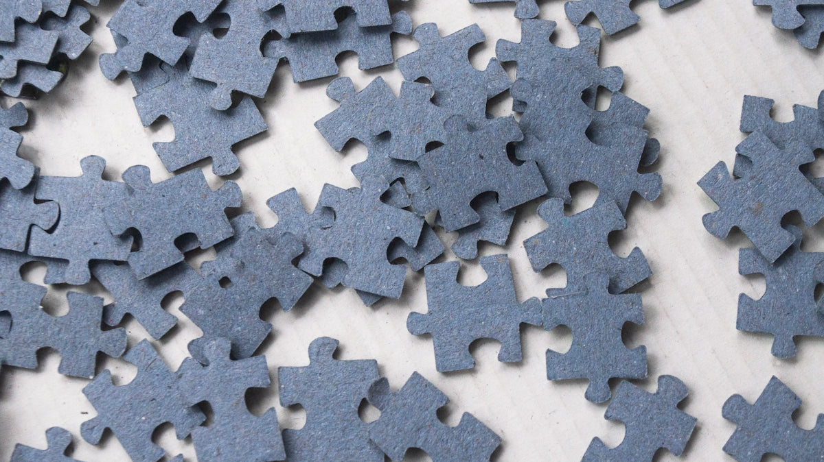 a pile of blue puzzle pieces on top of a table