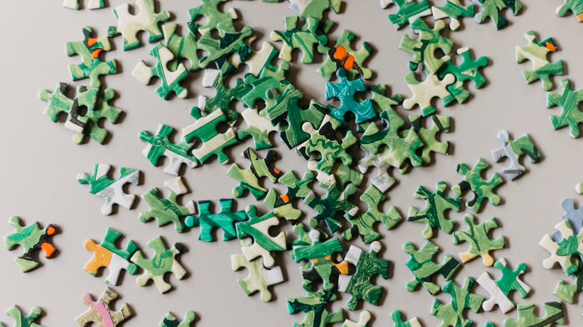 A pile of green and white puzzle pieces