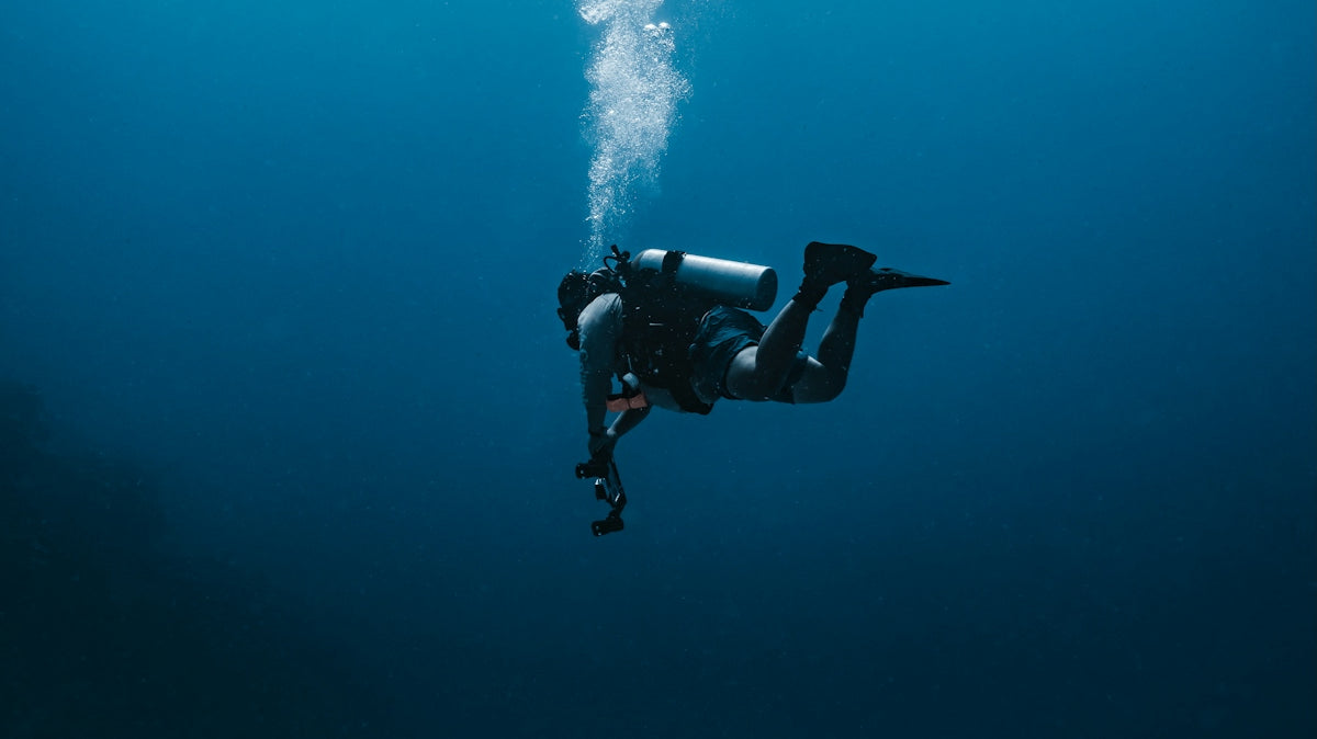 A scuba diver explores the deep blue sea.