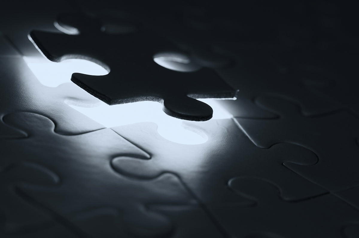 A single dark puzzle piece hovering above a matching empty slot