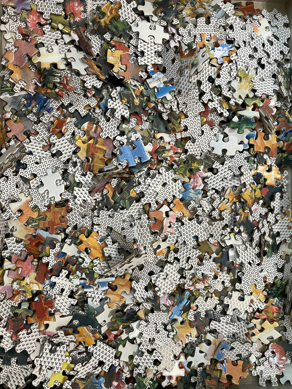 a pile of puzzle pieces sitting on top of a wooden floor