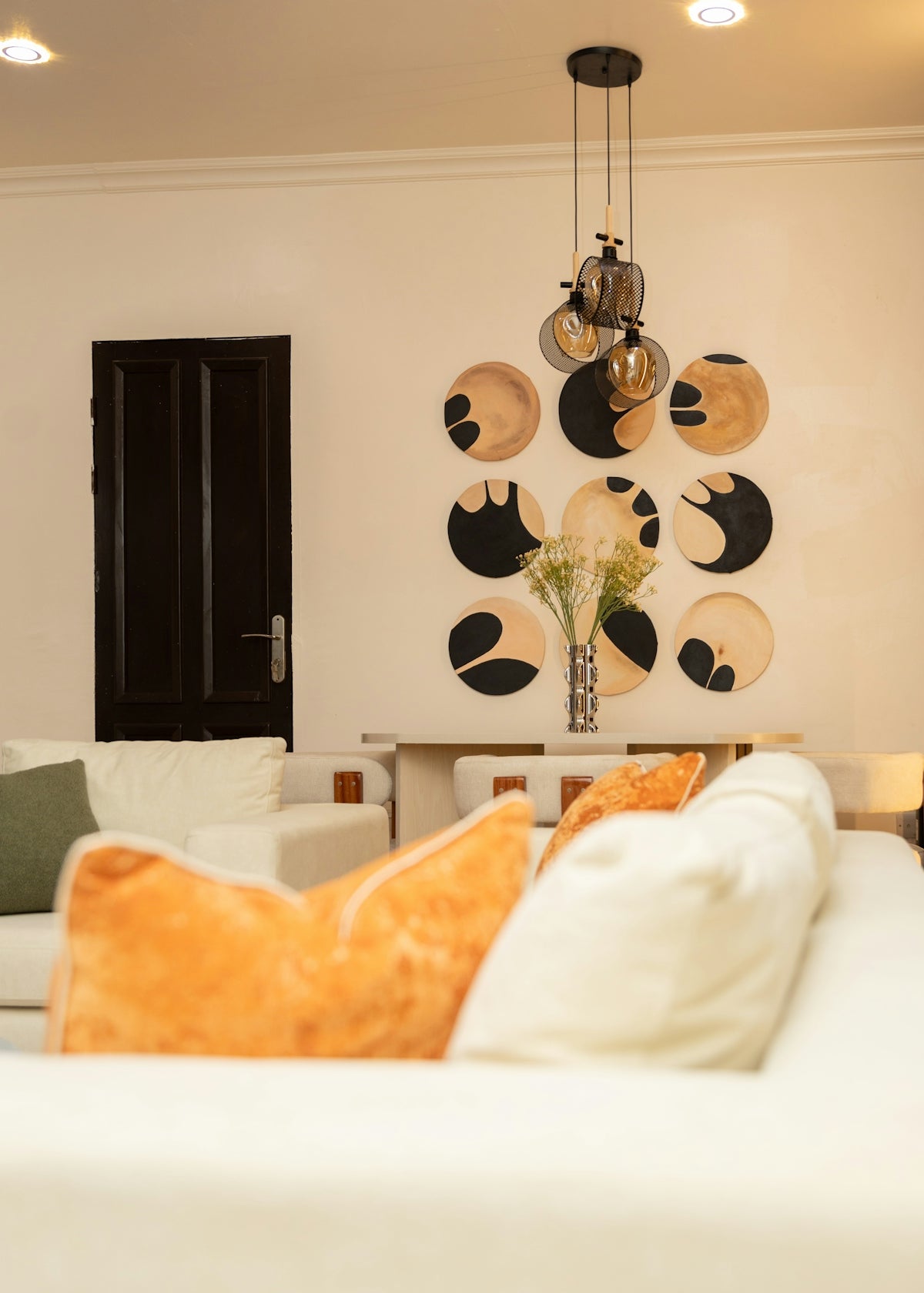 Elegant living room featuring circular wall art and modern lighting.